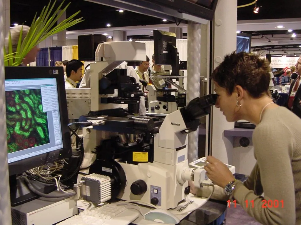 Noelle looking at a TE-2000 microscope equipped with fluorescence and brightfield cameras